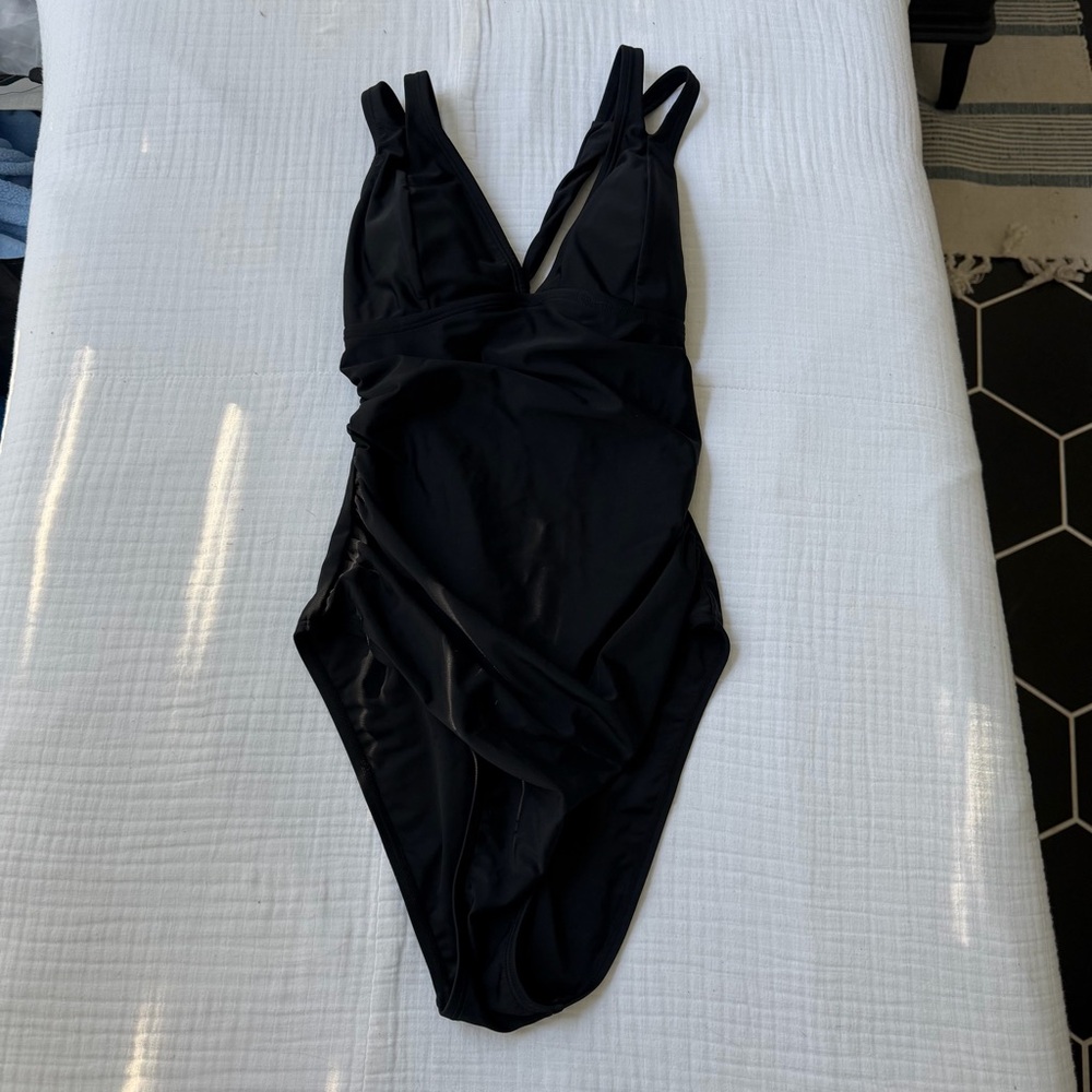 Black one piece swimsuit with adjustable straps and tie back detail. Size: M